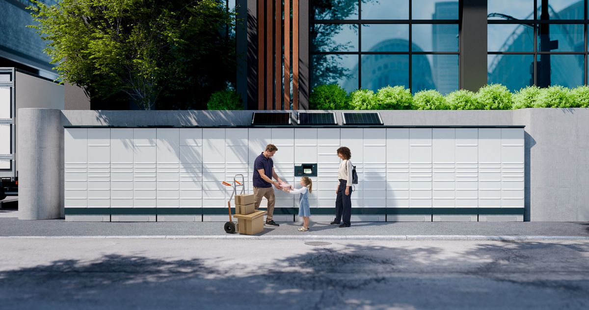 A family receives a package from a delivery person in front of a modern building with lockers and greenery.