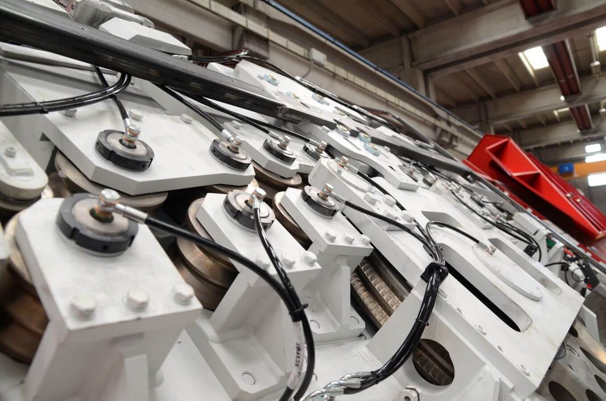 Detailaufnahme der hochpräzisen Mechanik einer MEP-Maschine mit zahlreichen Rollen, Lagern und Sensoren.