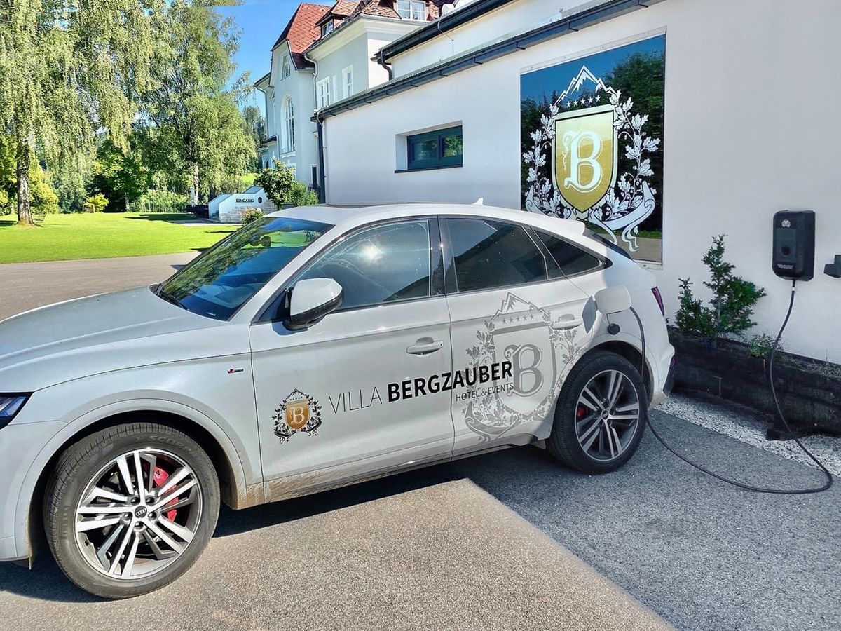 Elektroauto mit Villa-Bergzauber-Logo lädt an einer schwarzen KEBA-Wallbox.