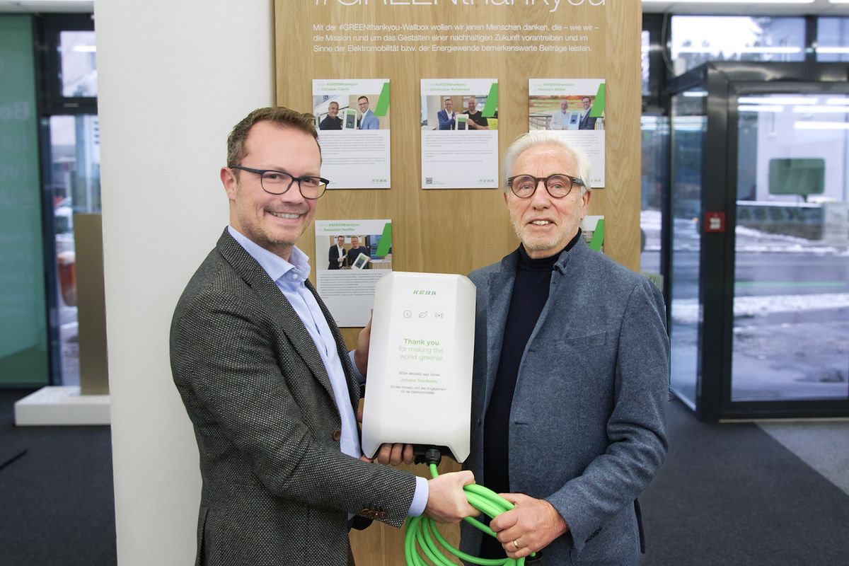 KEBA Energy CEO Stefan Richter presents designer and developer Johann Tomforde with a new KeContact P40 wallbox