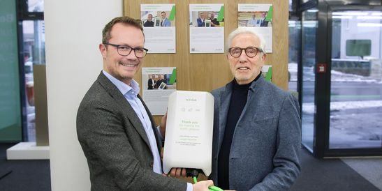 KEBA Energy CEO Stefan Richter presents designer and developer Johann Tomforde with a new KeContact P40 wallbox