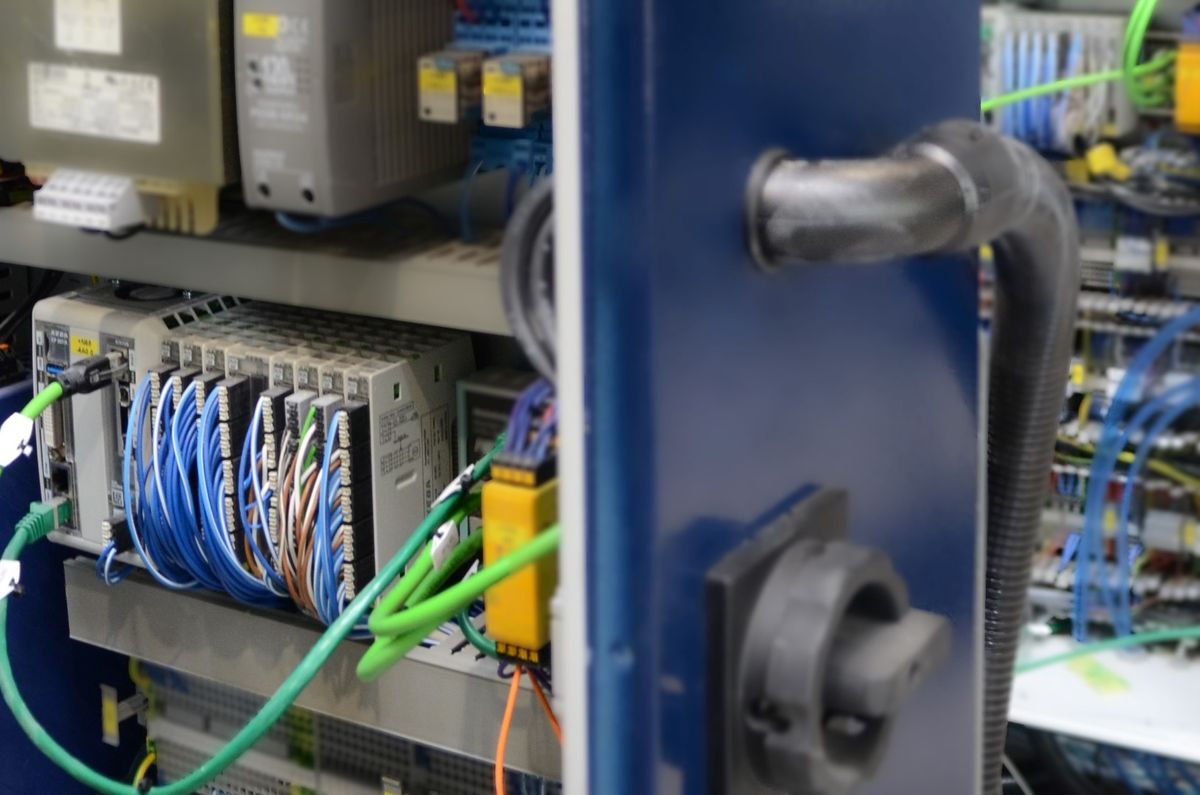 View inside an open control cabinet with wiring, interface modules, and automation components – symbolizing precise and connected control of industrial systems enabled by KEBA automation technology.