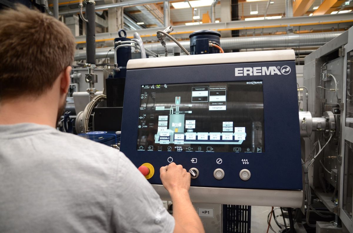 Operator controlling an EREMA system via a modern HMI touchscreen with graphical process display – illustrating precise machine control and automation enabled by KEBA technology in plastic recycling.