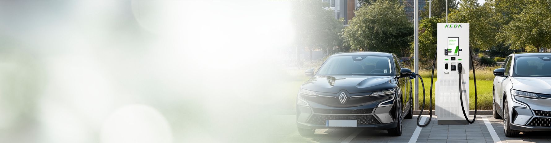 Deux voitures électriques se chargent à une station de recharge KeContact DCA10 en plein air.