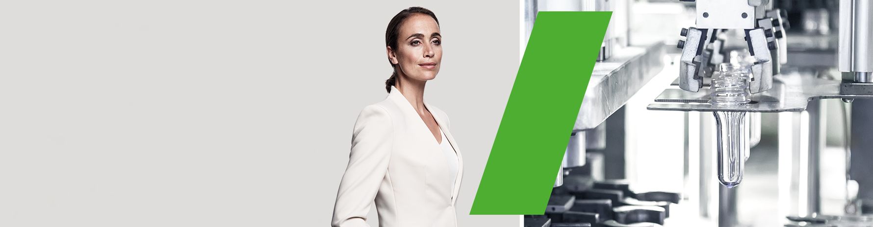Eine Frau in Weiß steht vor einer Maschine zur Herstellung von Kunststoffteilen.