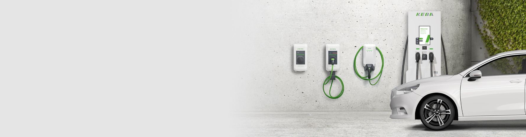 Two KEBA AC charging stations with green cables mounted on a concrete wall.