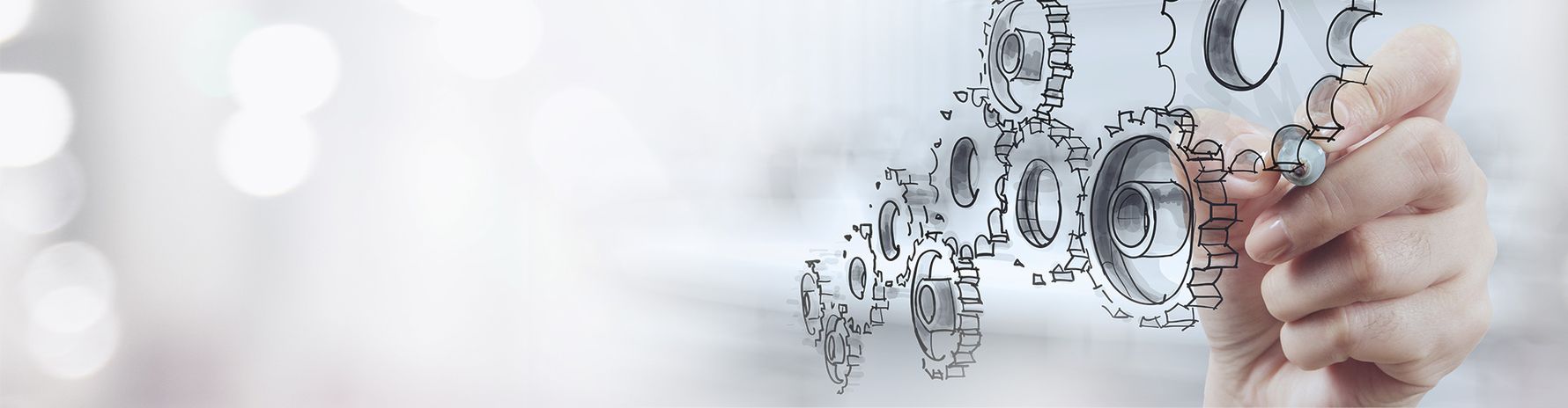 Headerbild mit Bleistiftskizzen von Zahnrädern die von einer Hand gemalt werden auf verschwommenem Hintergrund