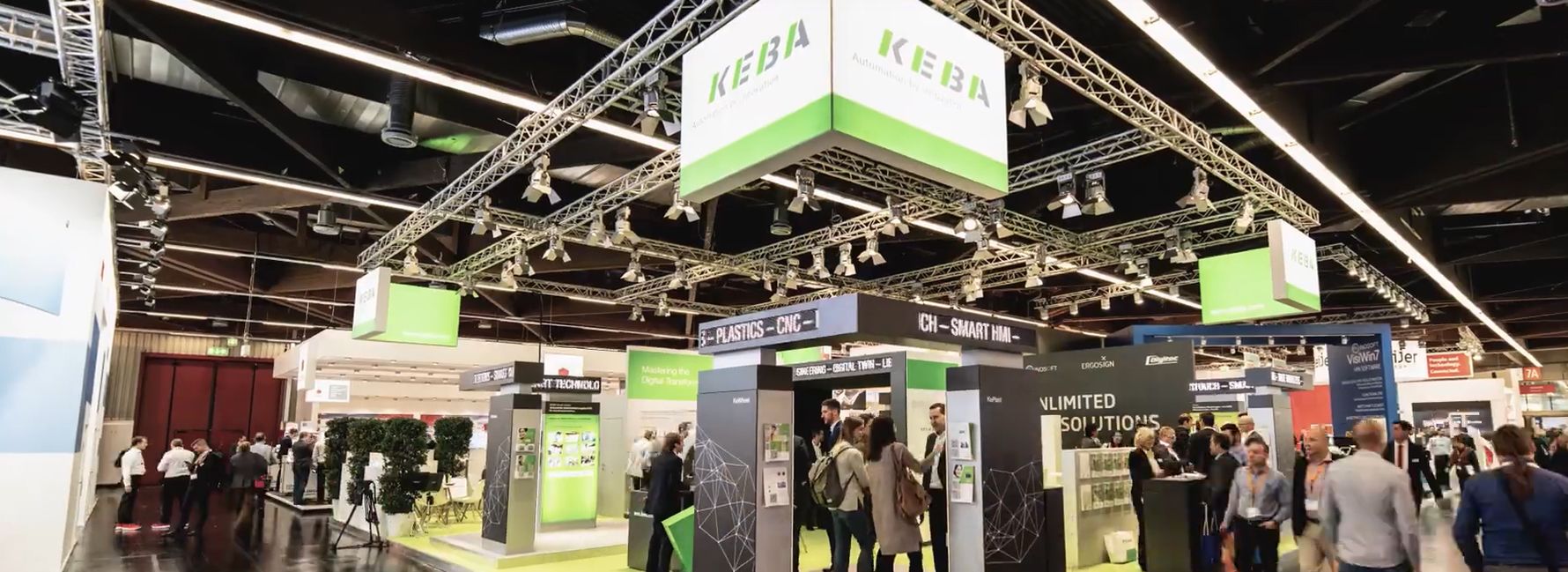 Overview of a large KEBA trade fair booth with many visitors, presentation areas, and focus topics related to automation, HMI, and Industry 4.0 solutions.