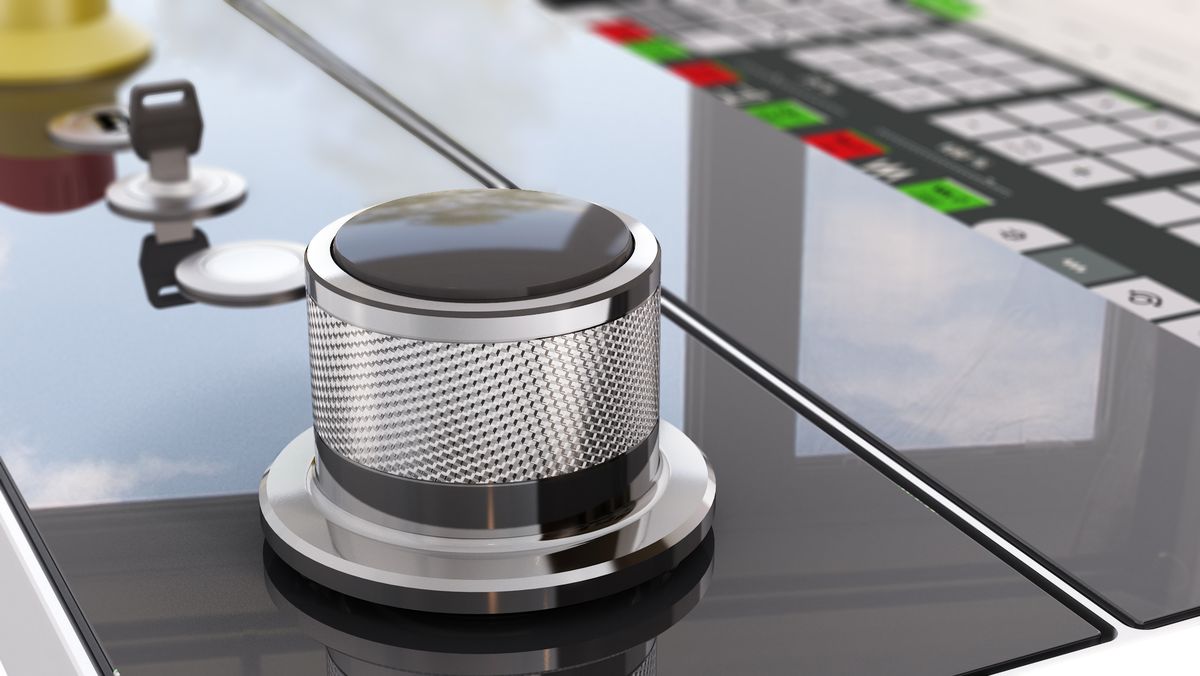 Nahaufnahme eines industriellen Drehencoders KEBA KeWheel auf einer modernen Bedienoberfläche mit Tasten und Not-Aus-Schalter.