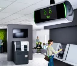 Asistentul digital KEBA KeBob cu față animată, montat pe tavanul unei sucursale bancare – sprijină clienții la terminalele de autoservire.