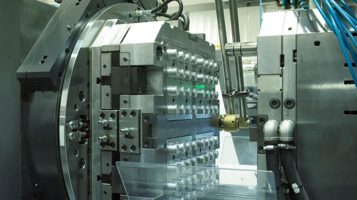 Detailaufnahme einer Präzisionsspritzgussmaschine mit geöffneter Form und mehreren Kavitäten – Symbol für Hochleistungsfertigung in der industriellen Automatisierung.