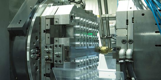 Detailaufnahme einer Präzisionsspritzgussmaschine mit geöffneter Form und mehreren Kavitäten – Symbol für Hochleistungsfertigung in der industriellen Automatisierung.