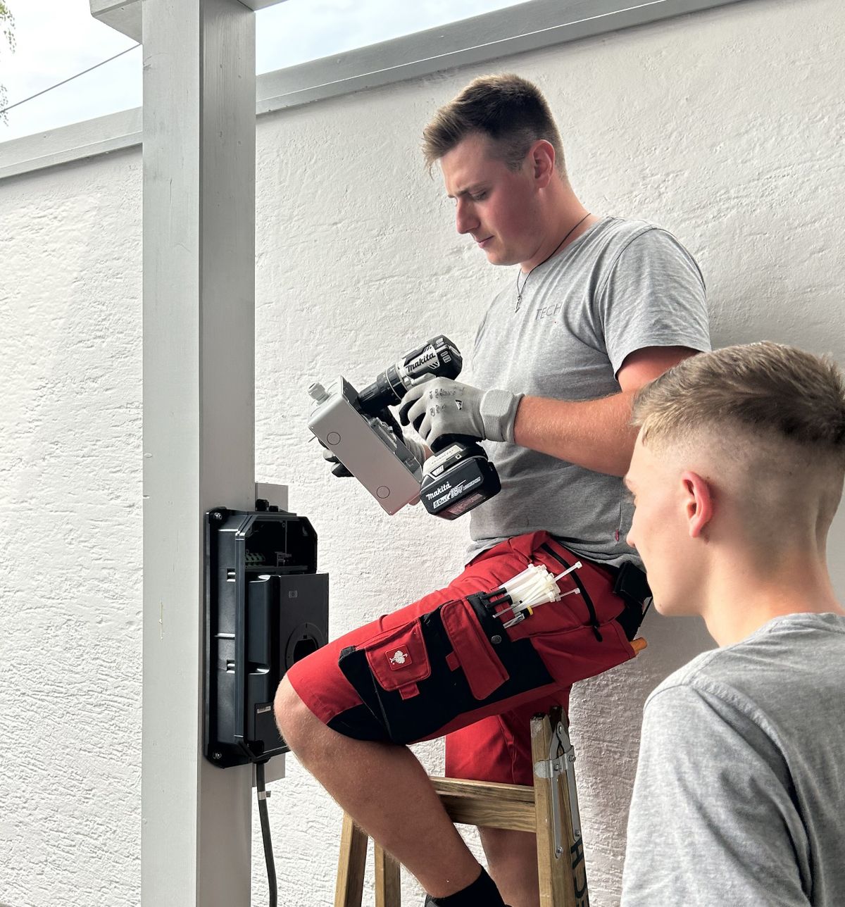 Ein Elektriker montiert das KEBA KeContact S10 Phasenumschaltgerät an einer Wand.