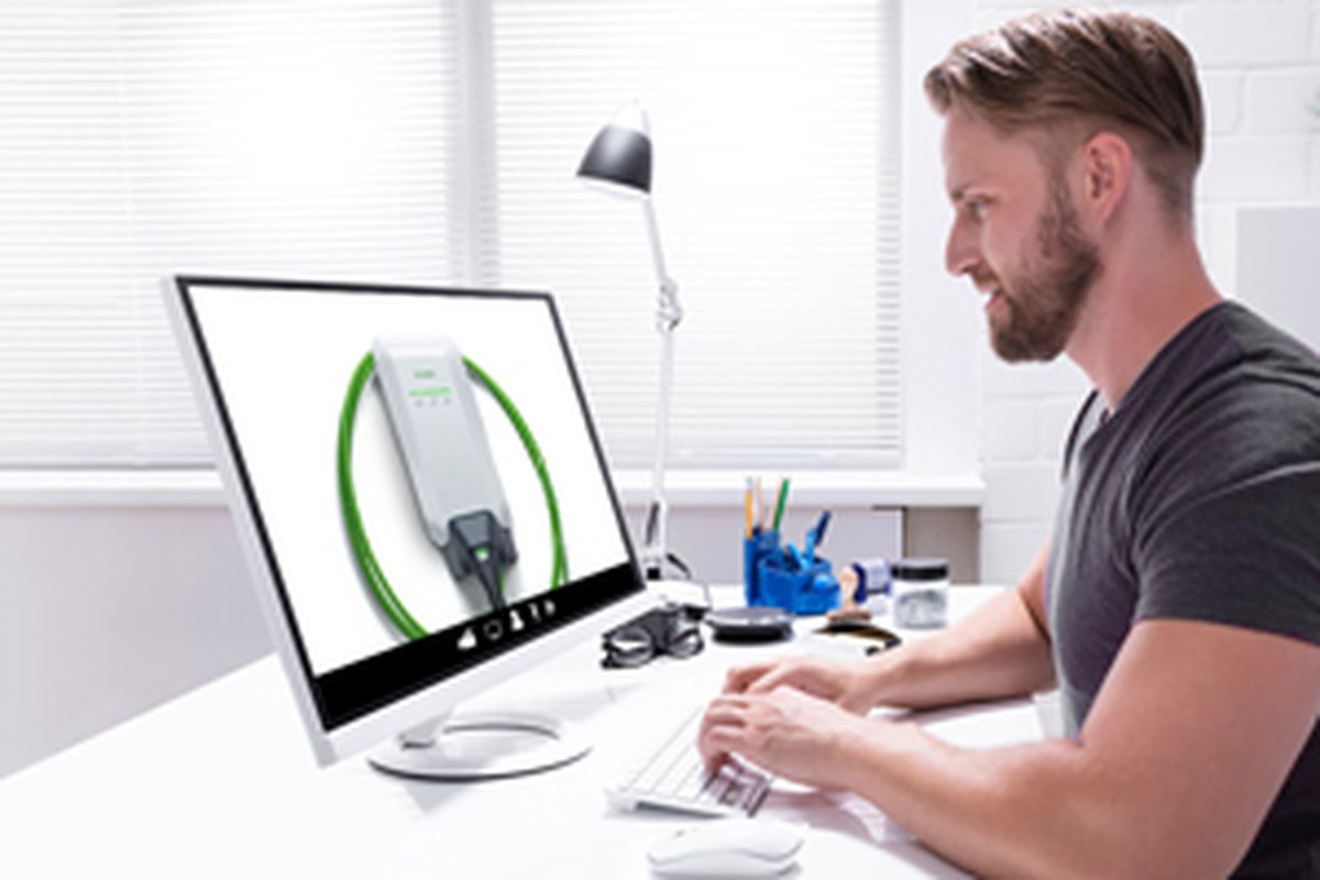 Man working at computer with KEBA wallbox image on the monitor.