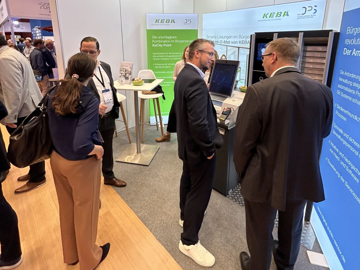 Messestandsbesucher unterhalten sich über die Geräte