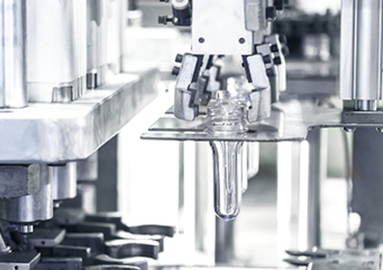 Detail einer Kunststoffmaschine mit Flaschenvorformlingen