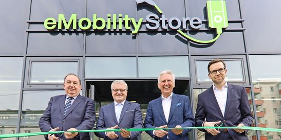 Official opening of the KEBA eMobility Store in Linz-Urfahr by representatives from KEBA and LINZ AG in front of the building with green “eMobility Store” signage.