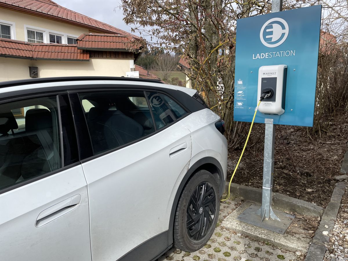 Electric vehicle charging at a KEBA charging station in a hotel parking lot.