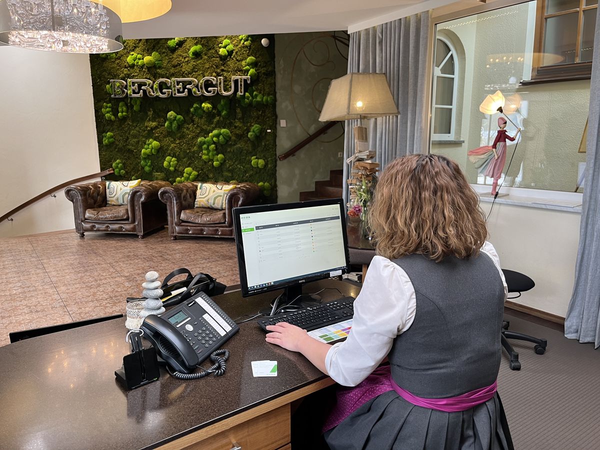 Hotel employee at the reception desk using KEBA billing software.