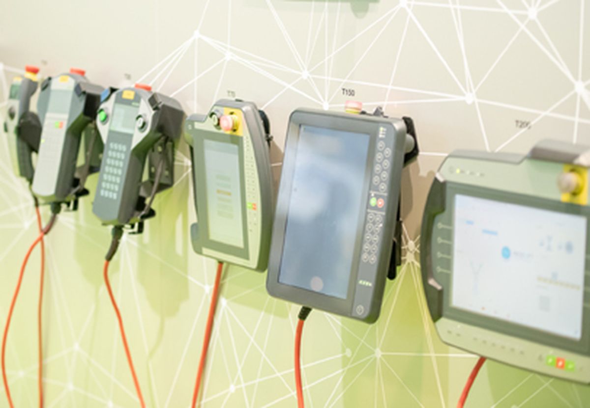 Several mobile HMI handheld devices mounted side by side on a display wall, showing different variants for industrial machine operation.