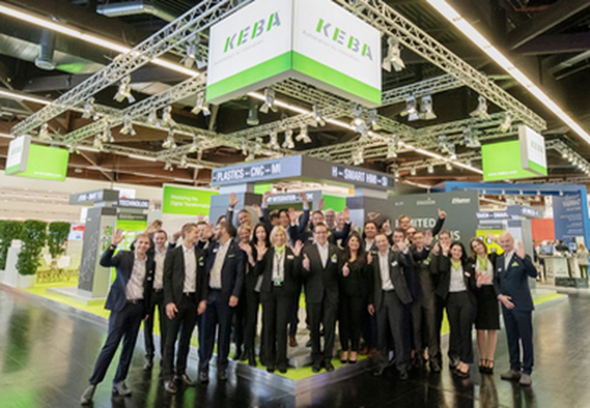 A group of employees standing together at the KEBA trade fair booth, presenting automation solutions in an open and welcoming exhibition environment.