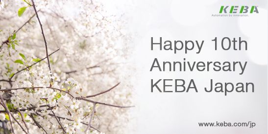 Cherry blossom branches appear on the left side of the image. On the right, the text reads “Happy 10th Anniversary KEBA Japan,” with the KEBA logo and the tagline “Automation by innovation” above it and the URL “www.keba.com/jp”  below. The image celebrates KEBA Japan’s 10th anniversary with a Japanese cultural reference.