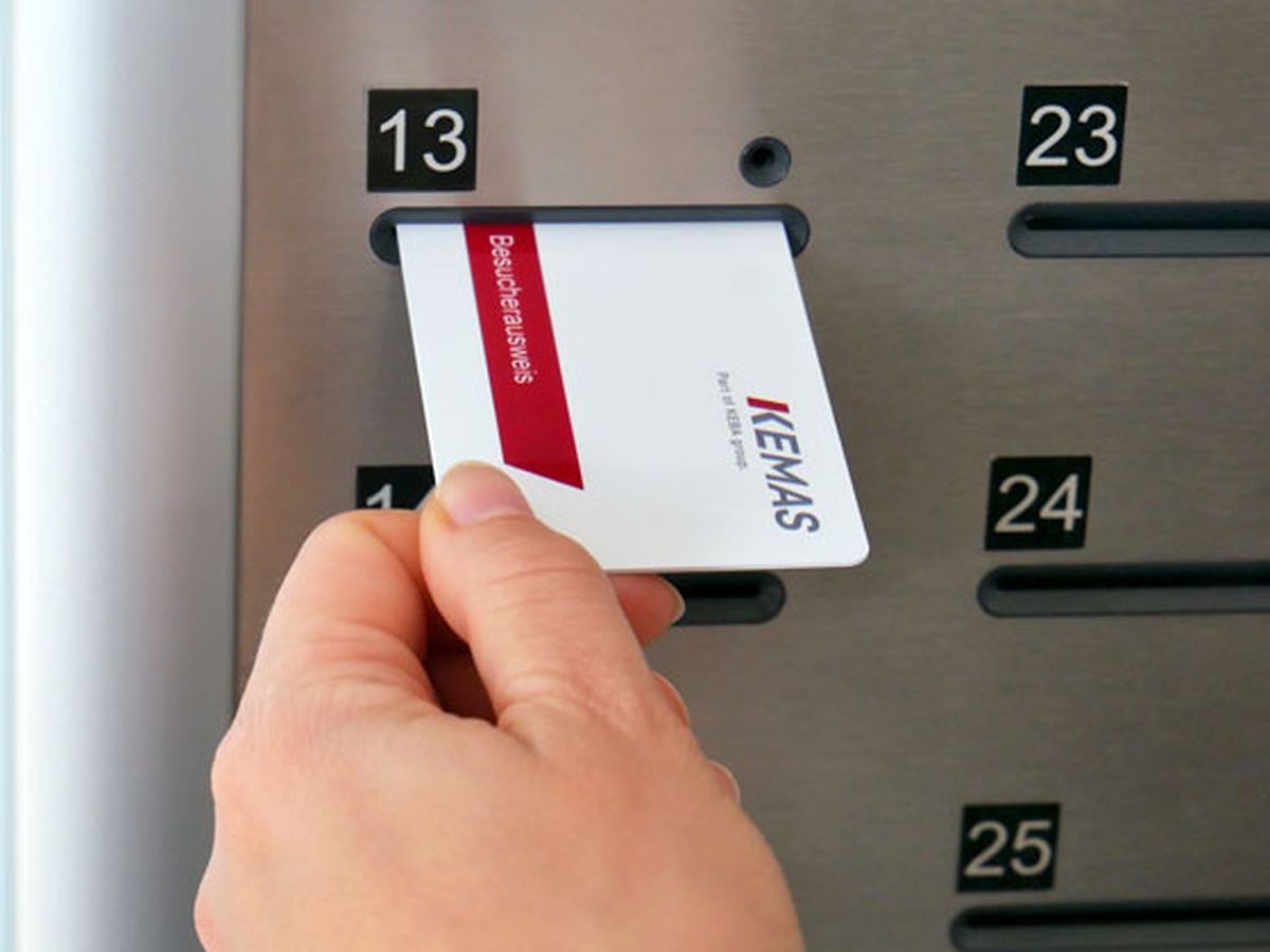 A hand inserts a KEMAS visitor card into a key compartment labeled 13.