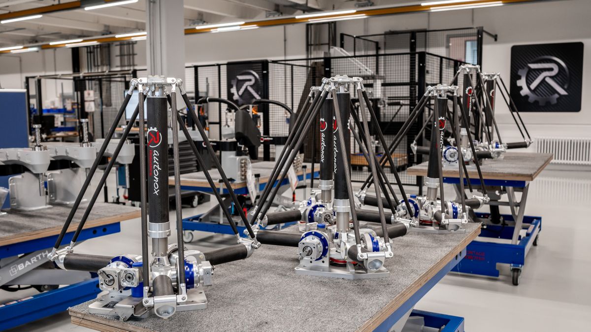 Mehrere identische Roboterarme des Typs autonox montiert auf Arbeitstischen in einer modernen Werkhalle, im Hintergrund Maschinen und das Firmenlogo an der Wand.