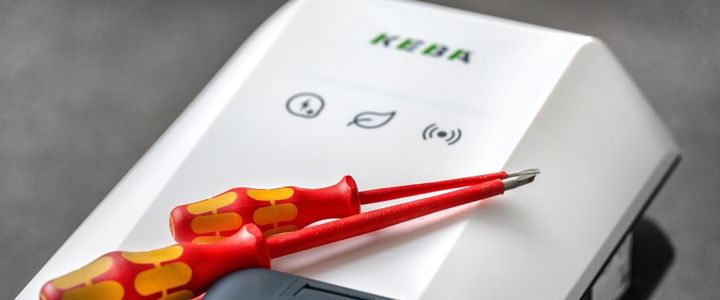 Zu sehen ist ein Computer mit dem KEBA eMobility Portal, im Hintergrund eine Wallbox.