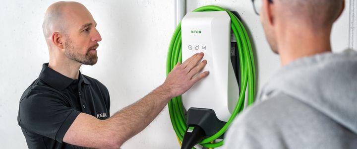 Zu sehen ist ein Computer mit der KEBA eMobility Solution und eine Karte mit der Aufschrift 'Stay Energized'