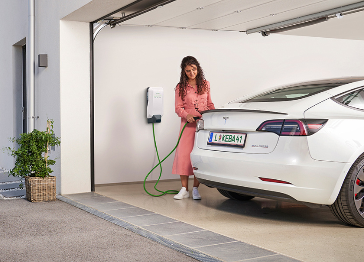 Zwei Fachleute im technischen Umfeld analysieren ein KEBA-Gerät und Daten auf einem Tablet.