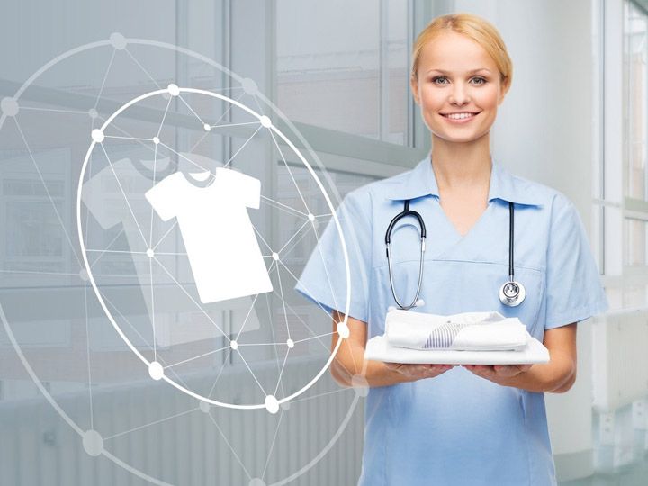 Nurse in uniform holding clothes in a hospital corridor, with a connected clothing symbol on the left.