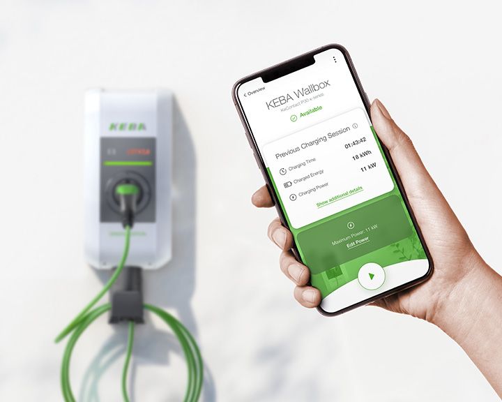 Un smartphone avec l'application eMobility de KEBA est visible, avec une borne de recharge en arrière-plan.