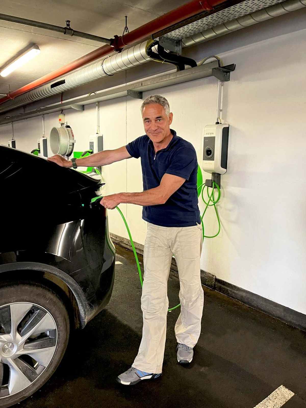 Christian Clerici lädt ein Elektroauto in einer Garage mit mehreren KeContact Wallboxen.