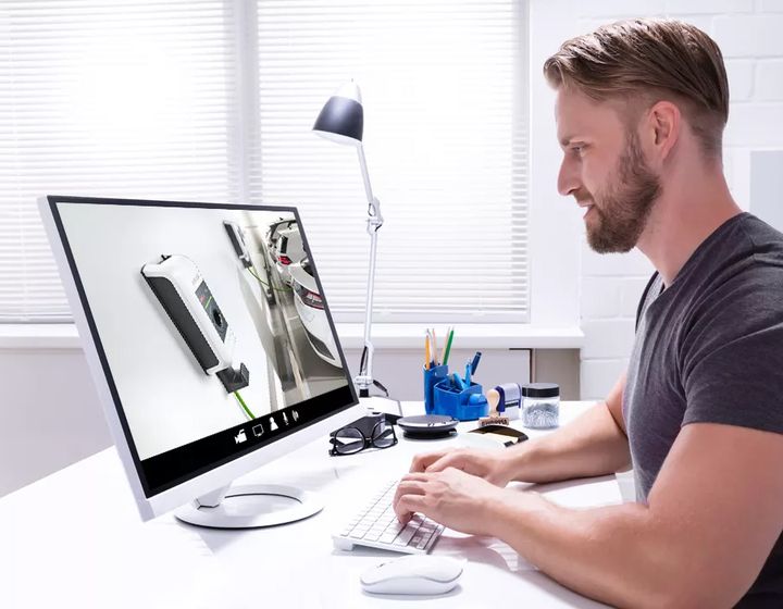 Mann sitzt am Schreibtisch und nimmt an einem Online-Training mit KEBA-Lösungen teil.