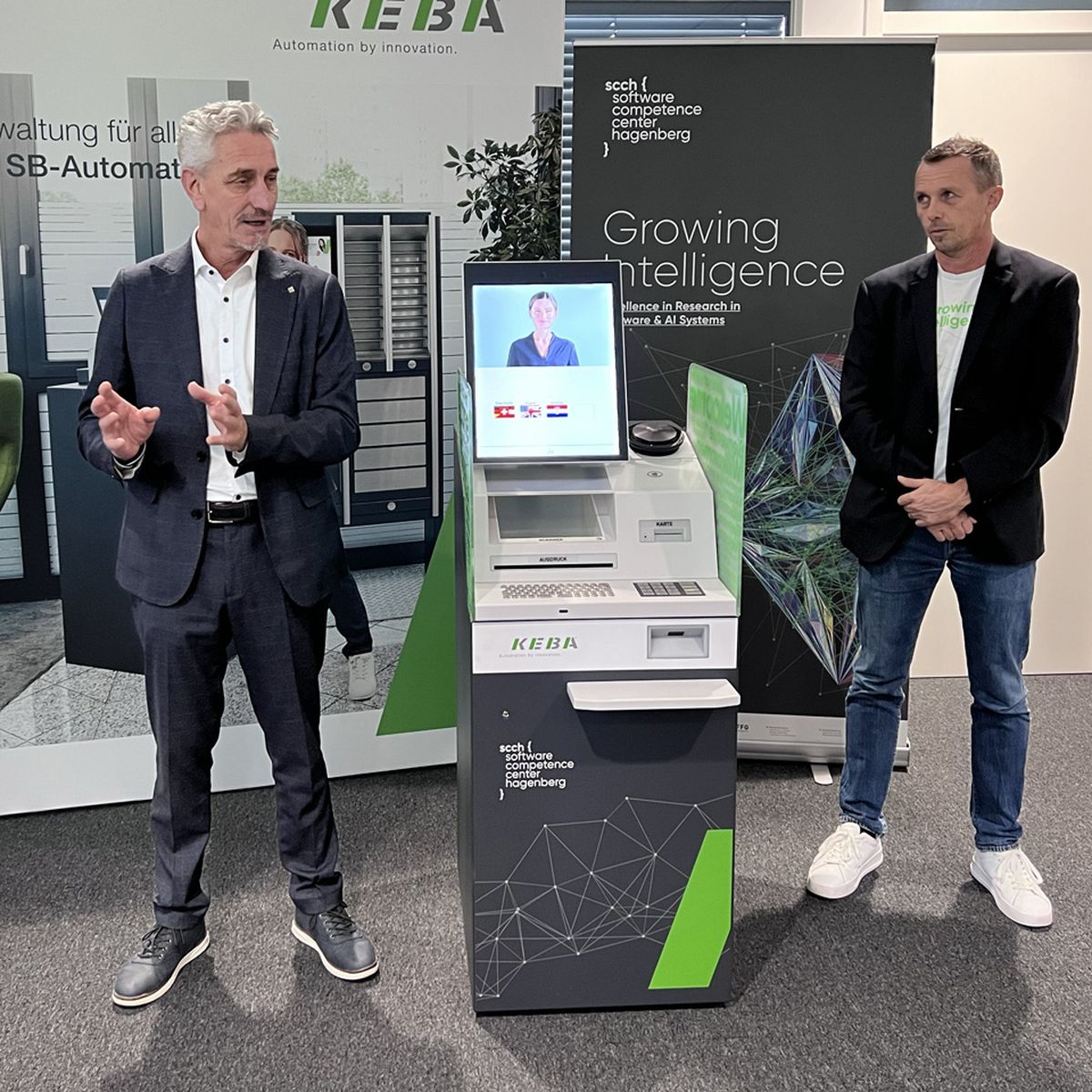Two experts are presenting an innovative KEBA self-service machine for digital management, developed in collaboration with the Software Competence Center Hagenberg.