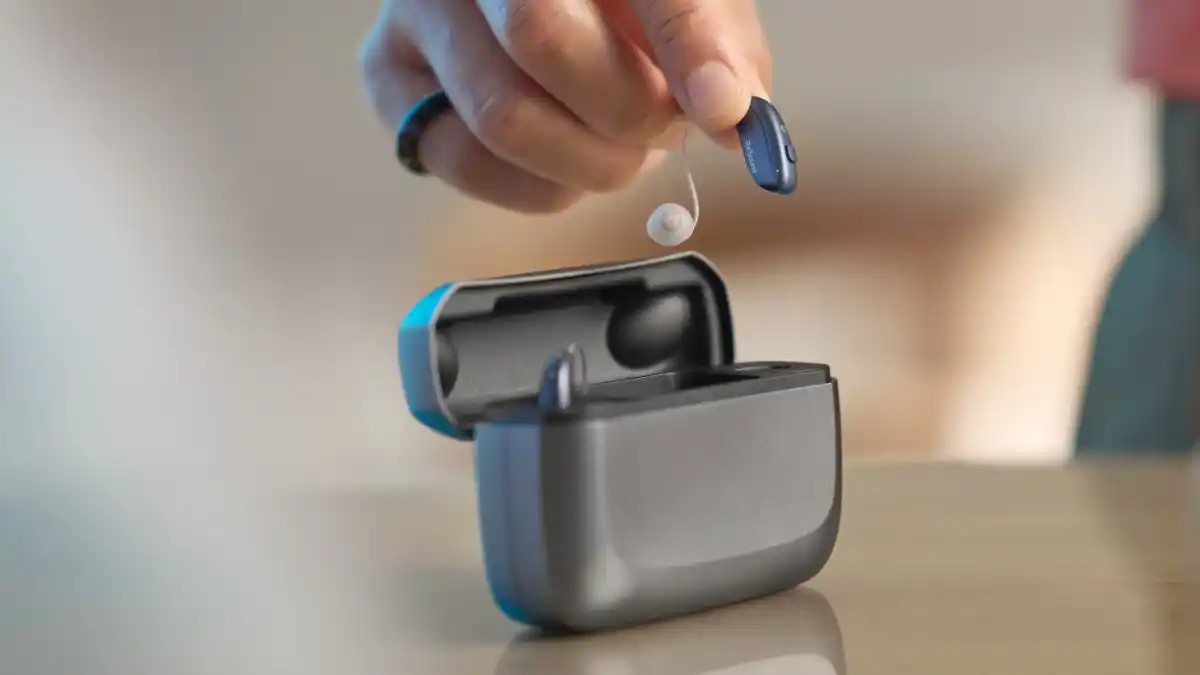 ReSound Vivia mit seinem Premium-Ladegerät, das einen integrierten Akku für bis zu 3 Tage mobiles Laden unterwegs bietet.