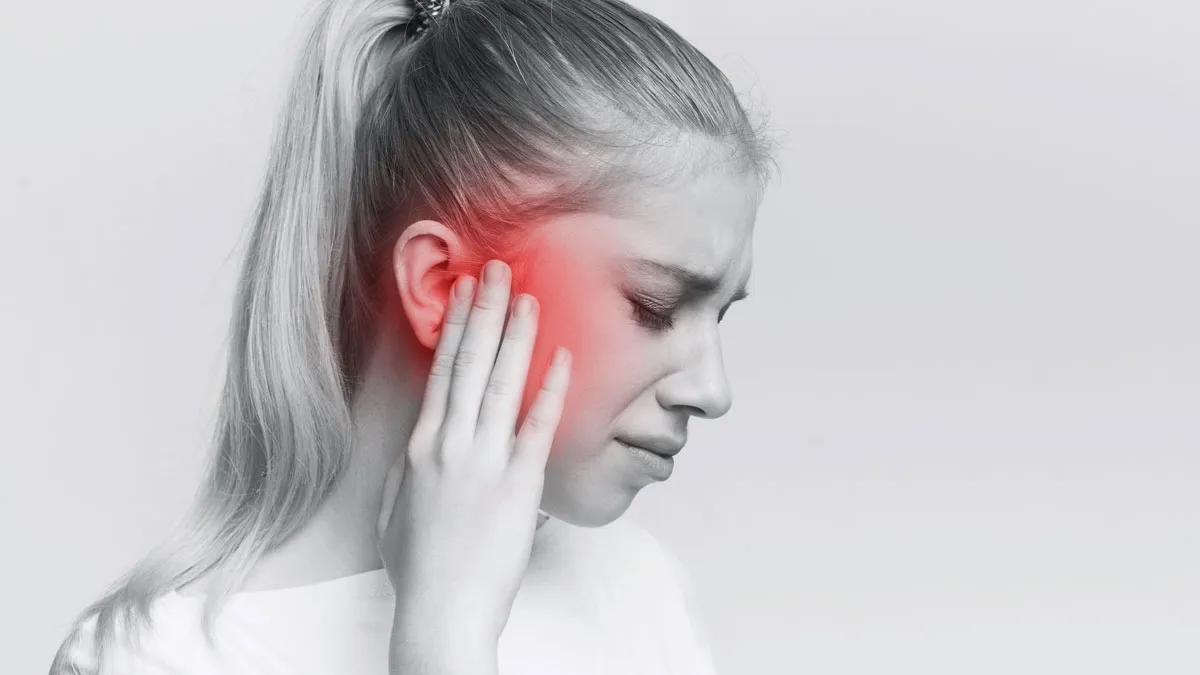 A young woman suffers from tinnitus