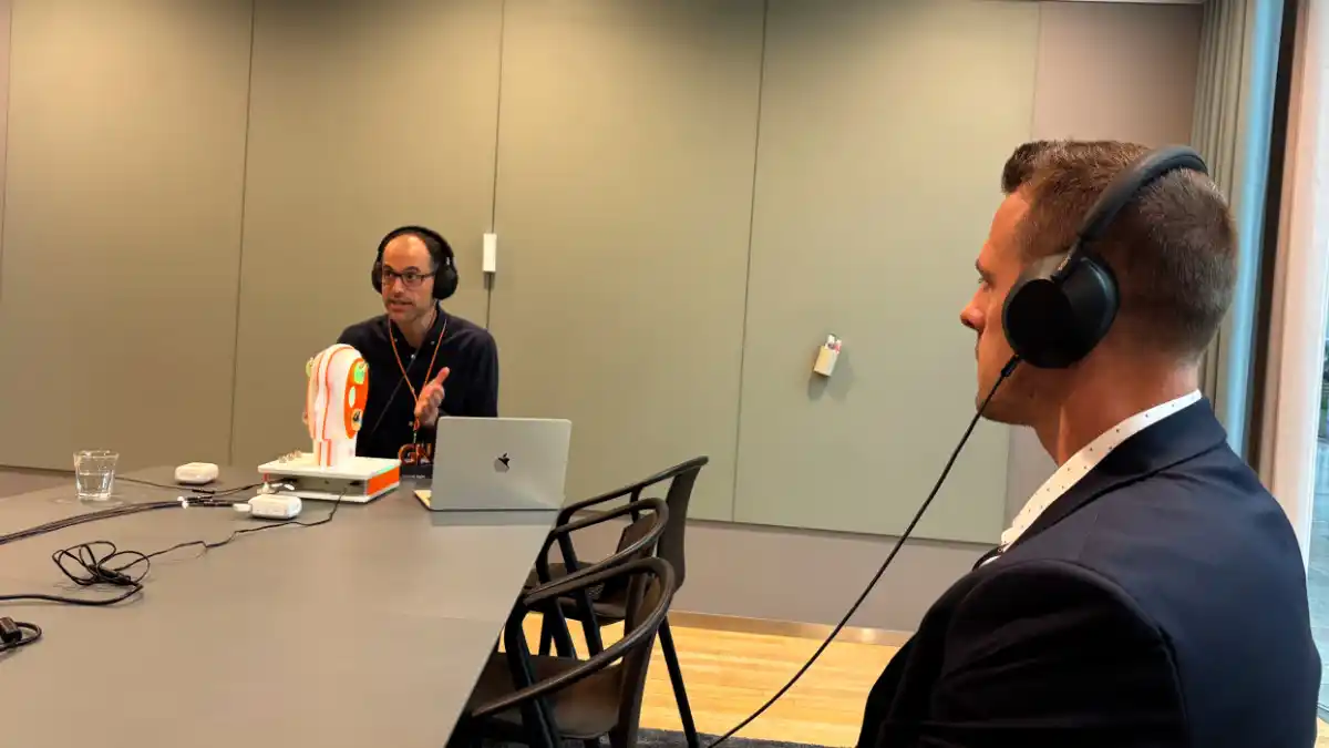 Dr Steve Taddei listens with headphones to simulated denoising demo