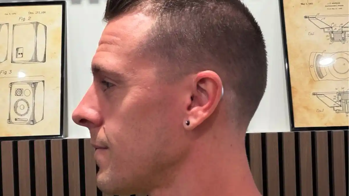 Silver hearing aid just peeking out from Dr. Taddei's ears