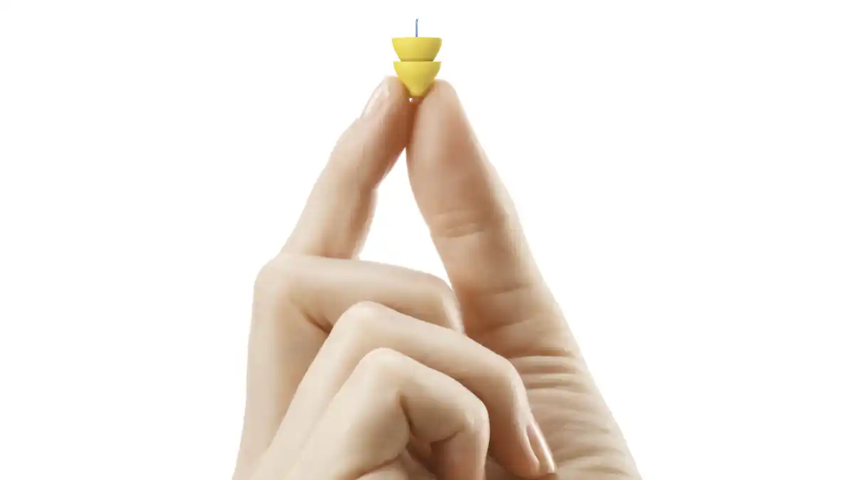 The Lyric hearing aid shown here for scale of size.