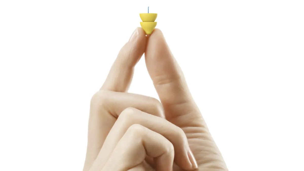 The Lyric hearing aid shown here for scale of size.