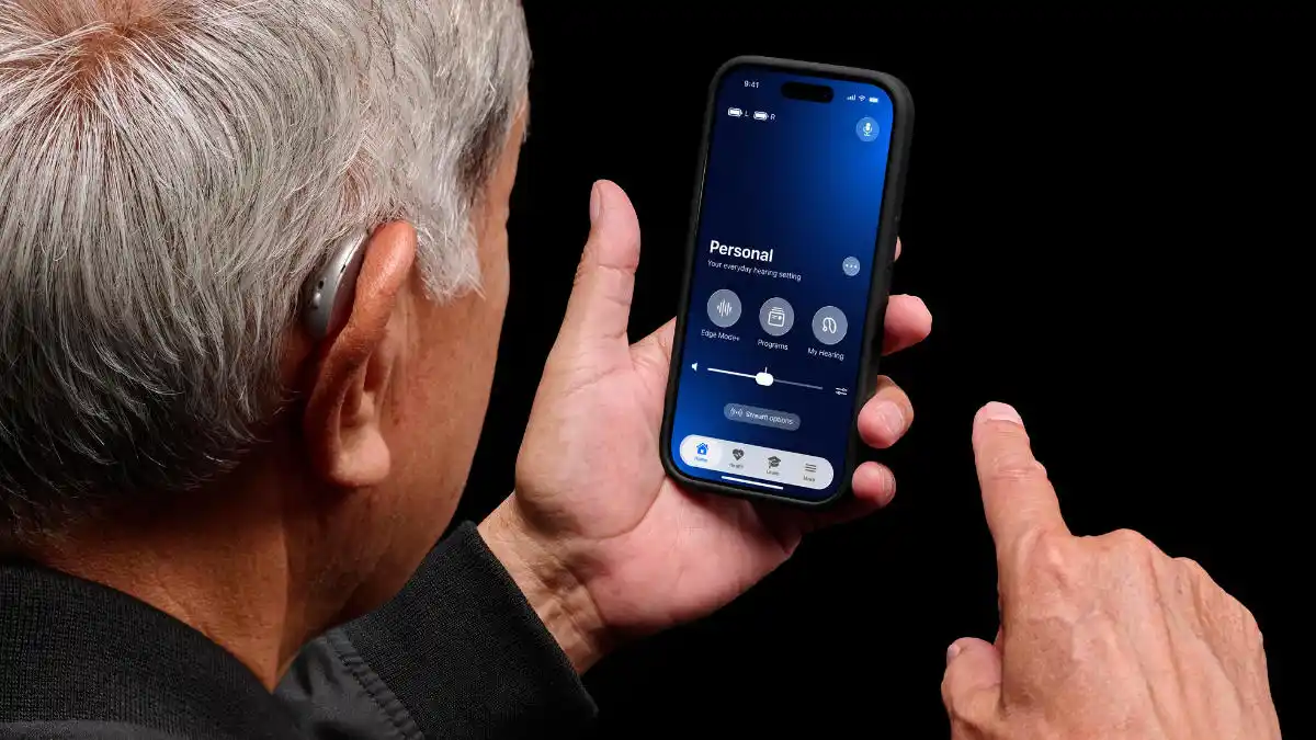 Starkey Omega AI+ on ear of man who is using Starkey app