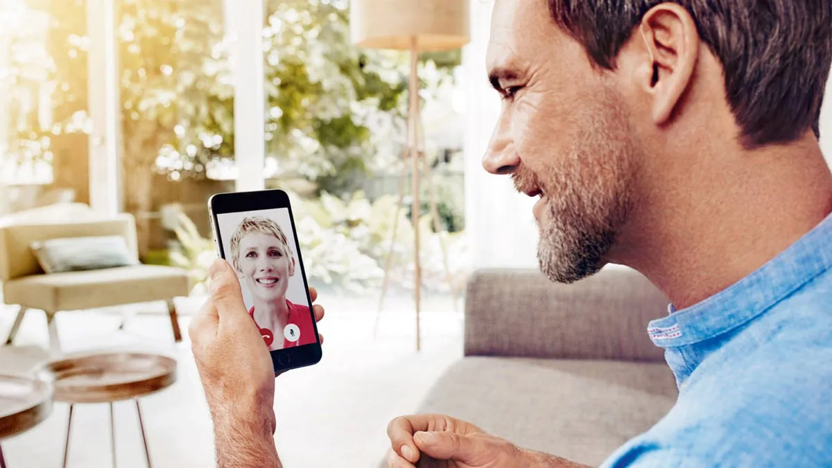 Man on video chat with hearing provider on smartphone