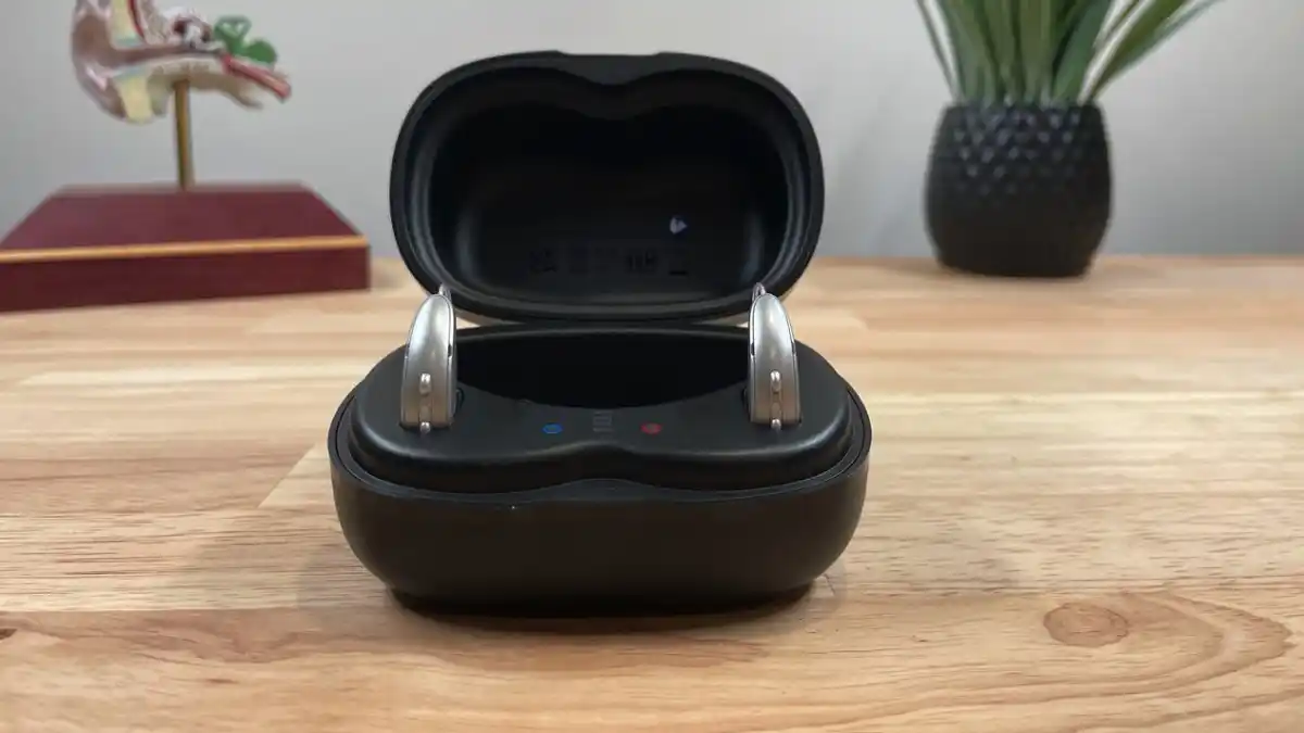 Person taking Omega AI aids out of charger