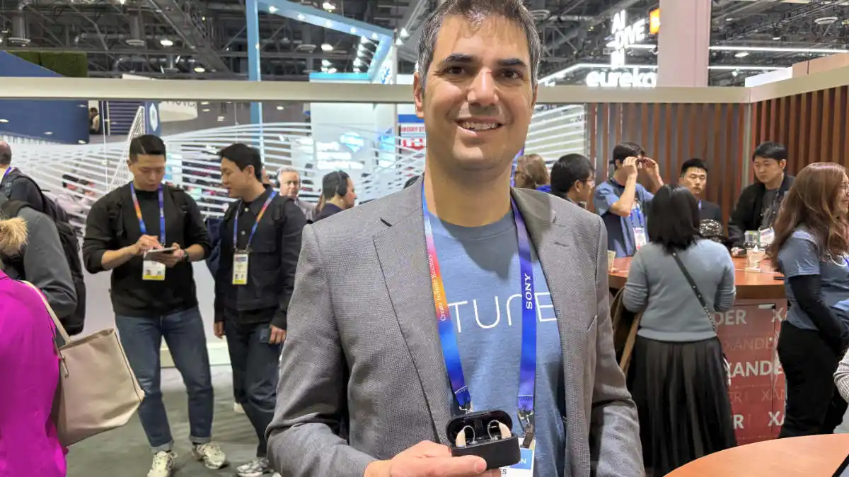 Tuned Ltd CEO Omri Gavish holding a set of hearing aids on CES Show floor