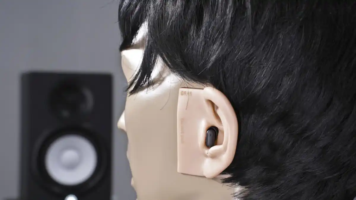 A photo from the HearAdvisor test lab of the KEMAR manikin fitted with a black Signia Silk IX hearing aid.