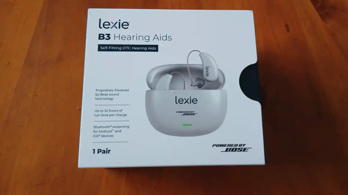 The Lexie B3 Powered by Bose box contains the hearing aids, charger and cables, domes, and various accessories. It also provides a QR code for activating the 12-month manufacturer warranty and a Quick Start Guide with phone number (779-212-7334) if you need help.