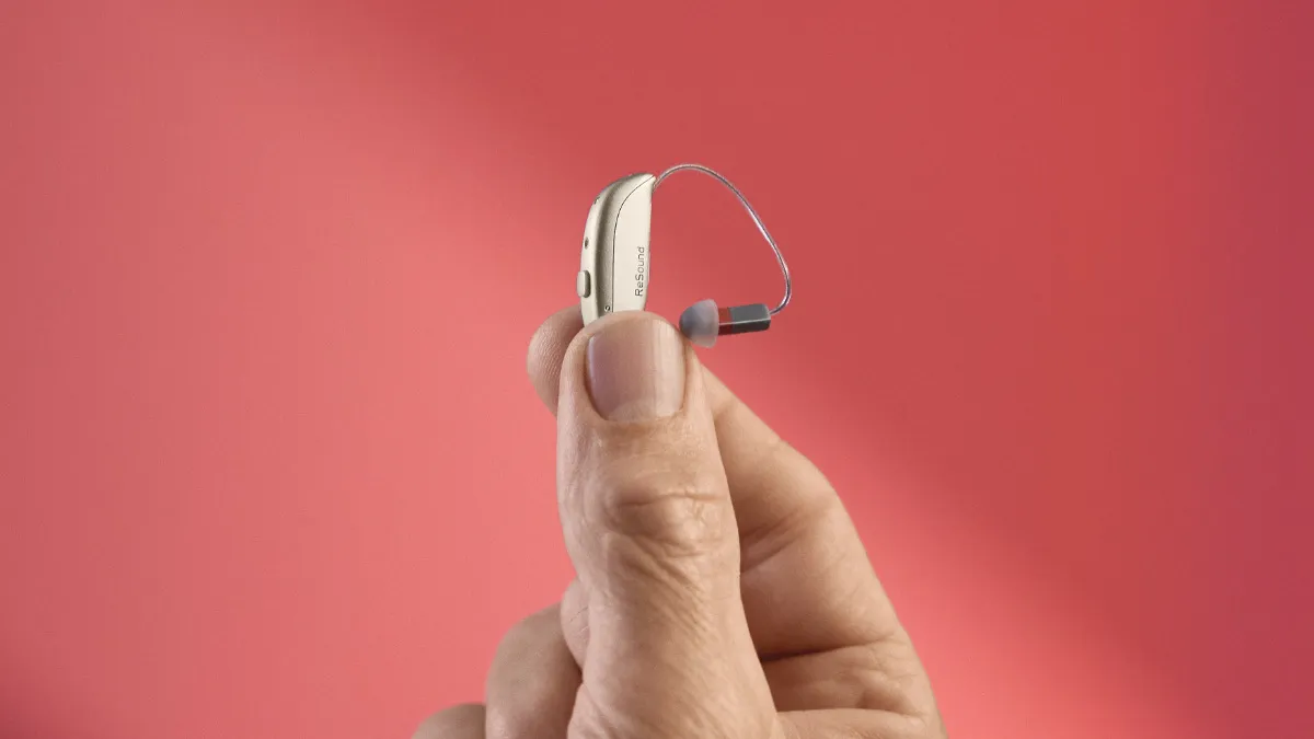 Small Savi mini-RIE hearing aid held in fingers