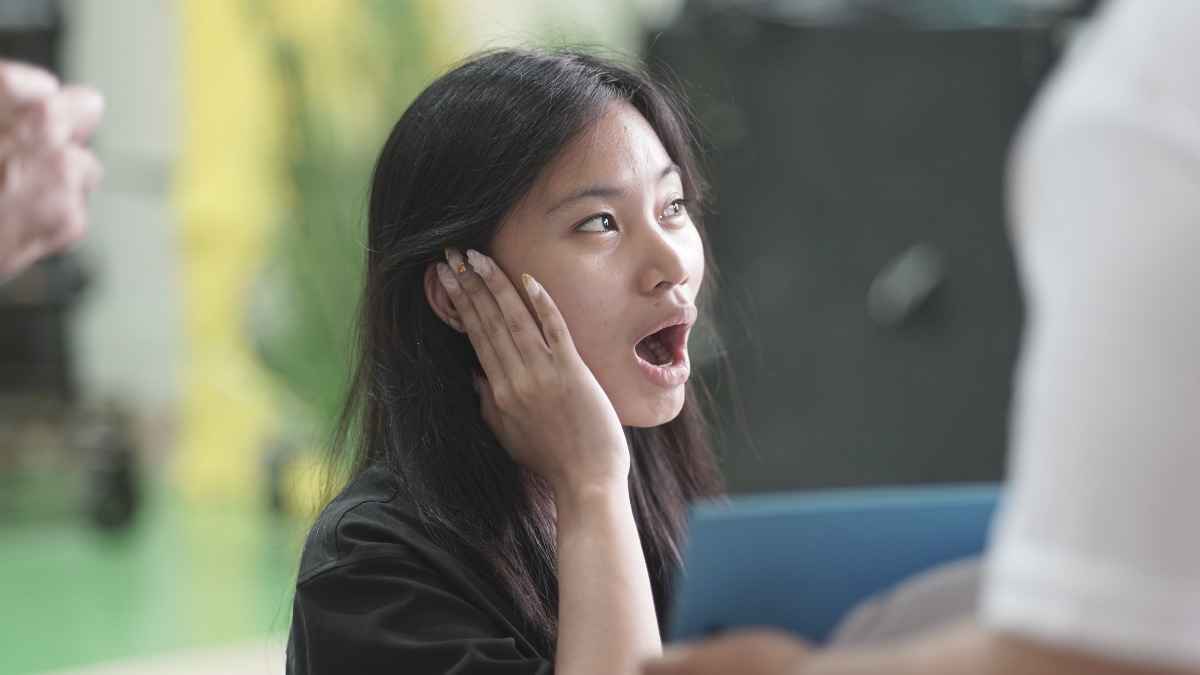 A young woman reacts to amplified sound from a hearing aid.